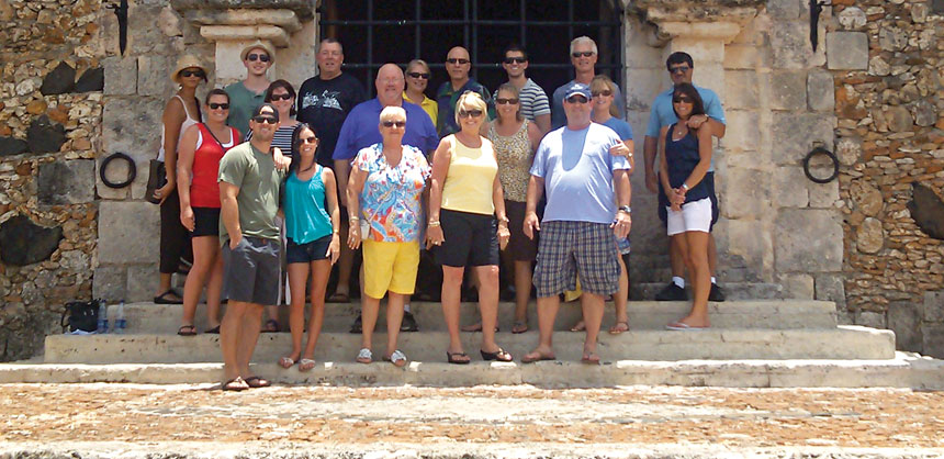 The Lynette Owens Advisory Council posed for a group shot in front of the Church of St. Stanislaus in Altos de Chavón, a replica of a 16th century Mediterranean village in the resort area of La Romana, Dominican Republic. Credit: Lynette Owens & Associates