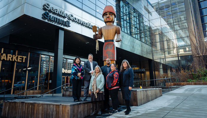 Celebration of Art speakers and dignitaries in front of "Mowitch Man" by Andrea Wilbur-Sigo at the entrance to Seattle Convention Center's Summit building. Photo by Cory Parris.